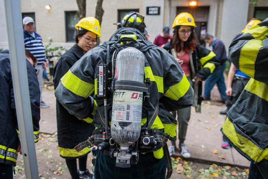 East Campus students try on firefighter gear, while Cambridge Fire Department members explain the gear’s purpose.