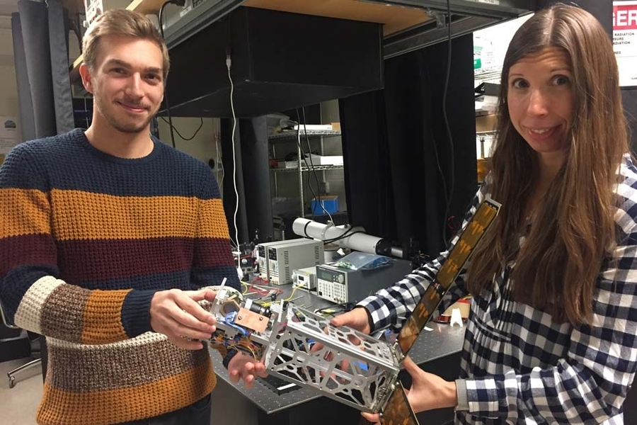 Ondrej Cierny (left) and Kerri Cahoy holding a CubeSat
