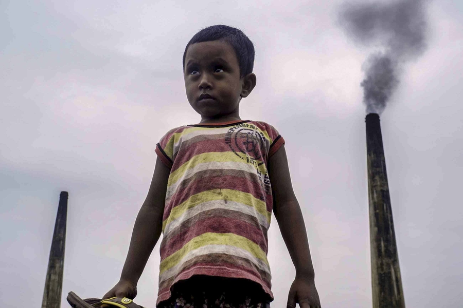 Four-year-old Nayem often plays atop large piles of coal used to fire kilns at a brick factory at the edge of Dhaka, Bangladesh. 