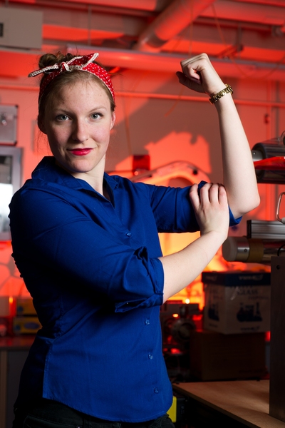 Larissa Nietner SM '14 PhD '17 poses as Rosie the Riveter in the lab. The word "Nietner" means "riveter" in German.