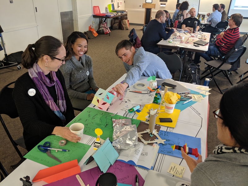 Technology and Policy Program master's students Annette Brocks (left) and Nelson Lee (right) engage in a rapid prototyping exercise with Tufts master's student Alexis Washburn (center) and other participants of the design thinking workshop.