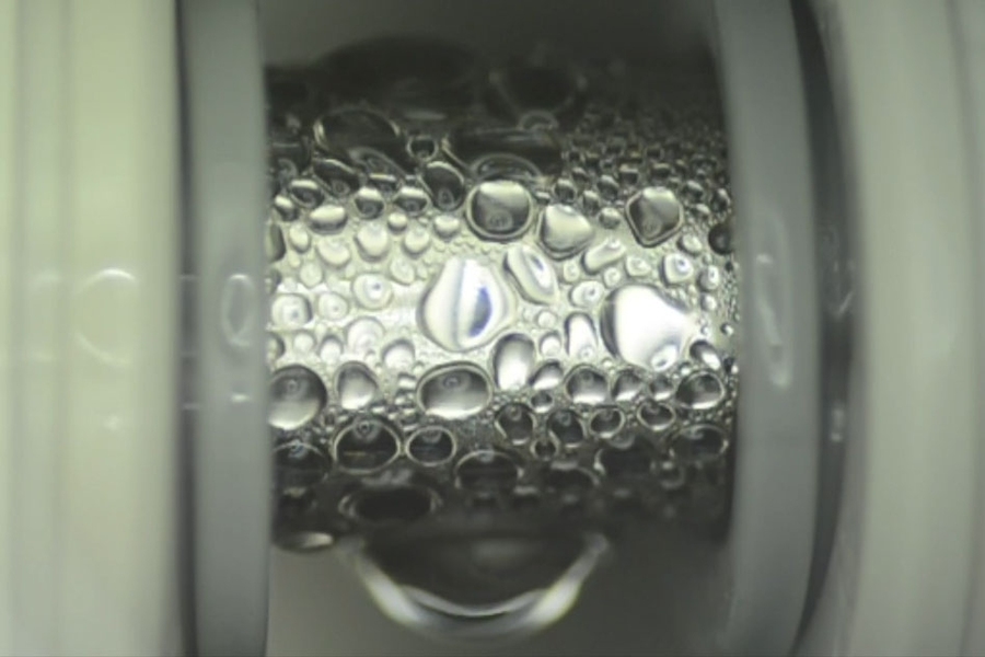 Specialized thin coatings developed by the MIT team cause even low-surface-tension fluids to readily form droplets on the surface of a pipe, as seen here, which improves the efficiency of heat transfer.