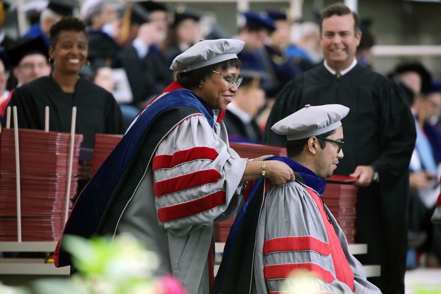 Paula Hammond, head of the Department of Chemical Engineering and the David H. Koch Professor of Engineering at MIT, places a hood on the shoulders of a new doctoral graduate at MIT’s Investiture of Doctoral Hoods and Degree Conferral ceremony.