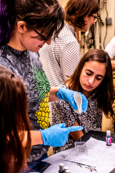 Rebecca Grekin ’19 of the MIT Department of Chemical Engineering and Daniella Koller of FIT work together during the Summer 2019 MIT and FIT AFFOA Workshop in Advanced Functional Fabrics. (MIT postdoc Katia Zolotovsky is in the background).