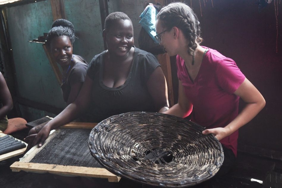 Senior Danielle Gleason (right) speaks with Goretti Ariago (center) and Salume Awiyo (left), employees of Appropriate Energy Saving Technologies, in Soroti, Uganda. Gleason has made two trips to Uganda to help streamline the production of charcoal briquettes which offer a low-smoke alternative for home cooking fuel.