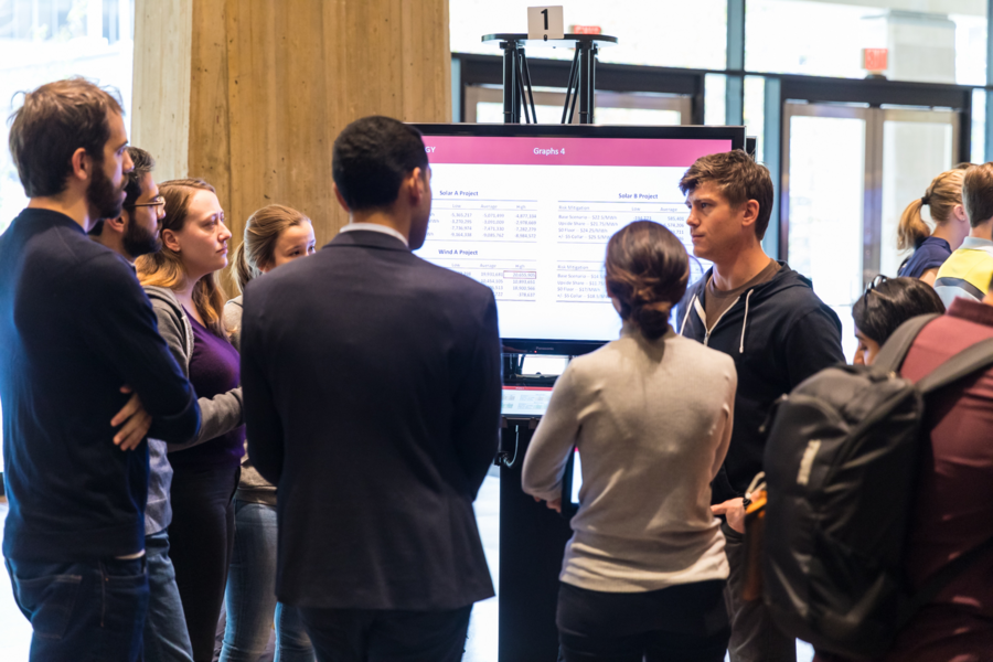 A group of students has their solution judged during the EnergyHack poster session.