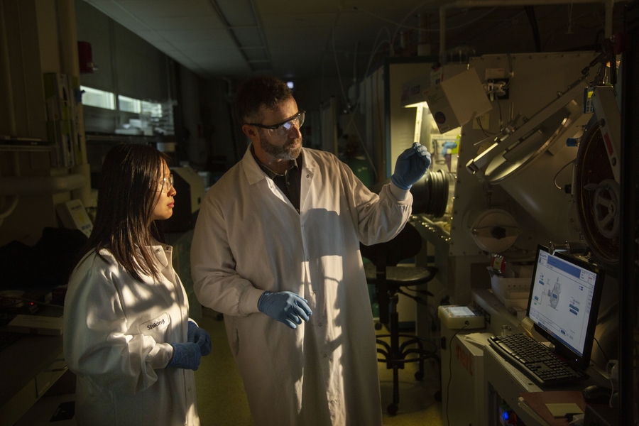 Professor Tonio Buonassisi (right) and research scientist Shijing Sun in front of the solar cell fabrication facilities in MIT’s Photovoltaics Lab. 