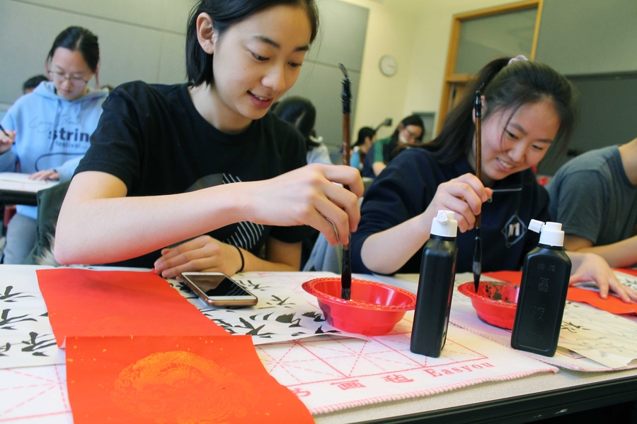 Students practice calligraphy.