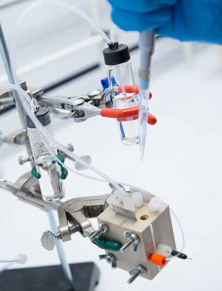 An MIT researcher pipettes an electrolyte solution containing an olefin material into a specially designed electrochemical cell. Inside the cell, voltage plus an electrocatalyst converts the olefin into an epoxide widely used in making consumer products. 