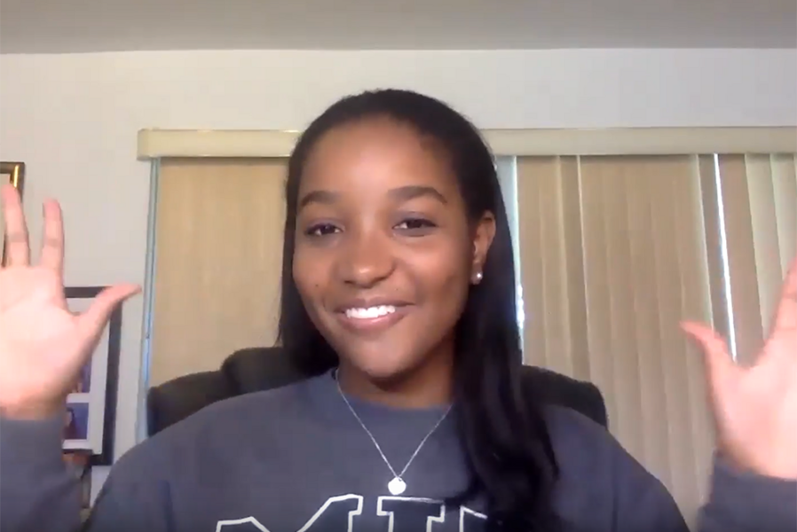 Danielle Geathers, president of the MIT Undergraduate Association, smiling and waving both hands to new first-year students