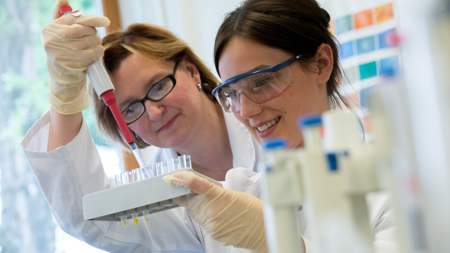 Photo of two female scientists in a lab experimenting with test tubes