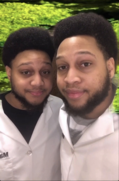 Screen capture of Miles and Malik George in a TikTok video with footage of amoebas in the background.