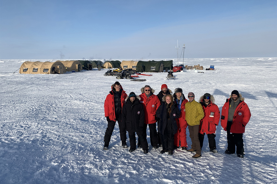 Group of scientists outside their research station on the Arctic ice