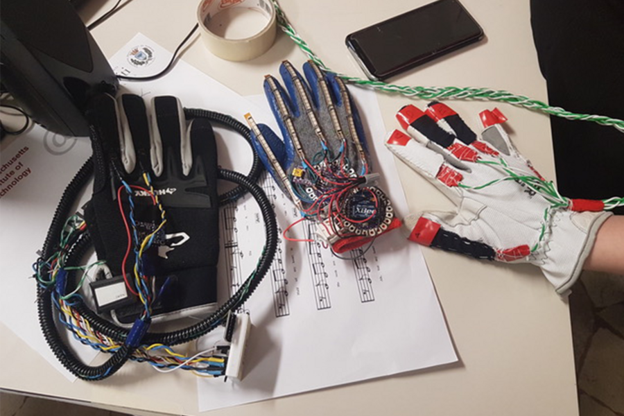 Photo of three gloves with wires and sensors attached along the fingers