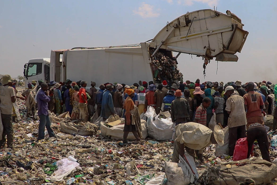 A crowd of people surround a truck unloading waste at a landfill site in Bulawayo, Zimbabwe. 