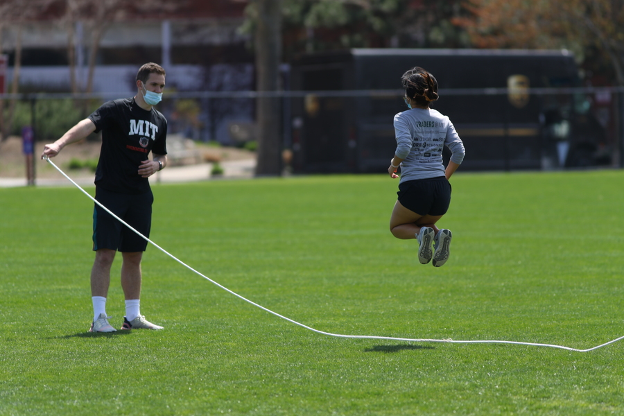Photo of an MIT student in grey long-sleeved shirt and black shorts taking part in the jumprope event.