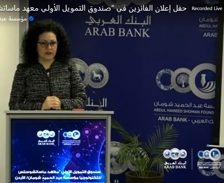 Video capture of a woman standing at a podium featuring the Arab Bank logo.