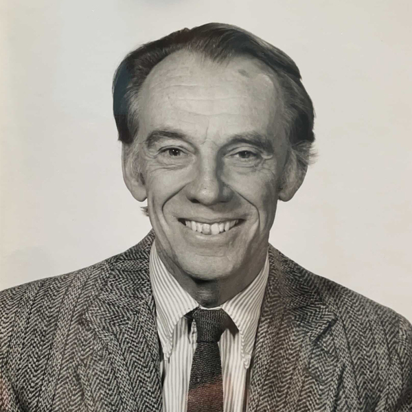 Black and white portrait of Justin "Jake" Kerwin wearing a suit and tie