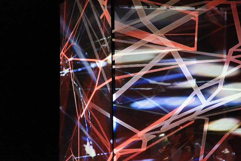 Image of colorful beams of light passing through a clear plate in a spiderweb pattern