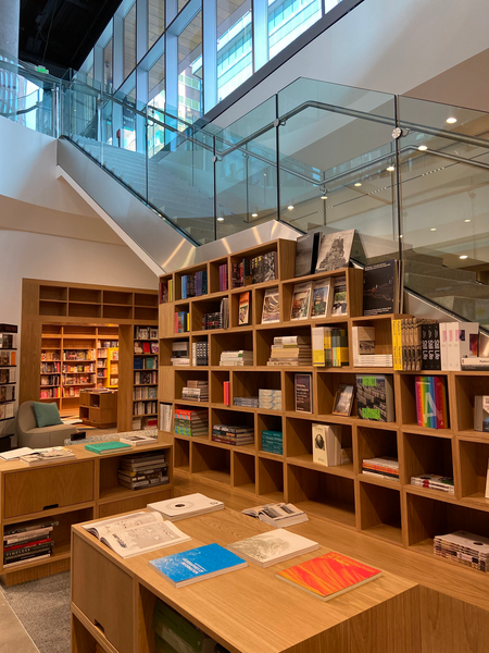 Photo of the interior of the MIT Press Bookstore showing bookcases under a glass staircase