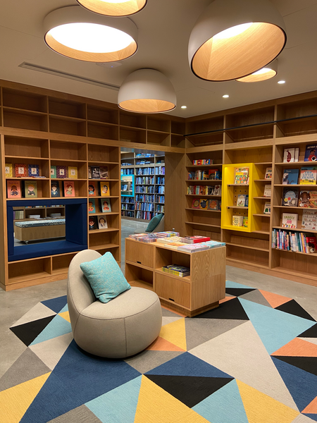 Photo of the children's section inside the new MIT Press Bookstore, with a colorful tesselated carpet