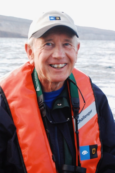 Portrait photo of Fred Frey wearing a life jacket and smiling with a water scene behind him