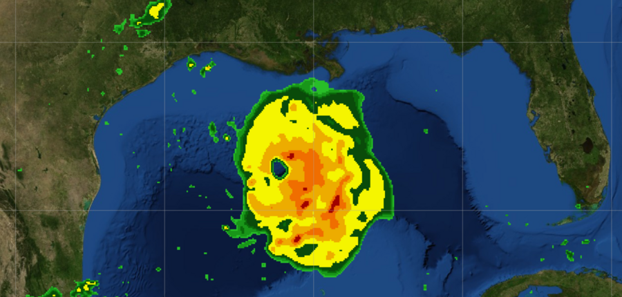 A radar-like image showing a hurricane, represented by a circle colored yellow and red, in the blue Gulf of Mexico. The green terrain of the Gulf Coast is visible.