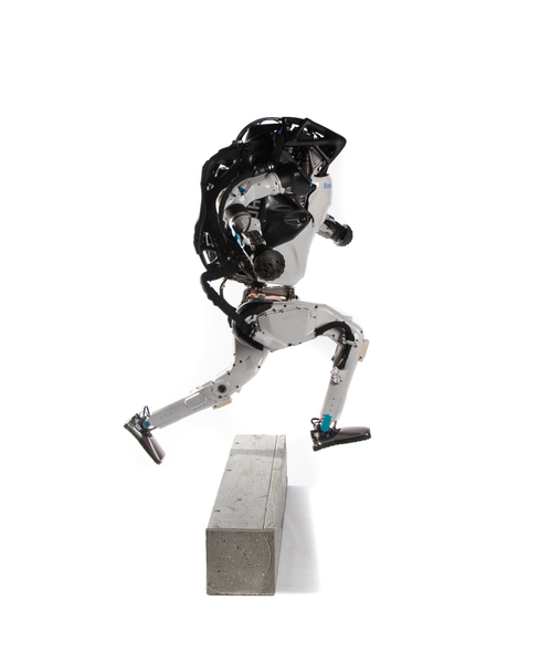 Photo of Atlas, a roughly human-shaped metal robot, leaping over an obstacle