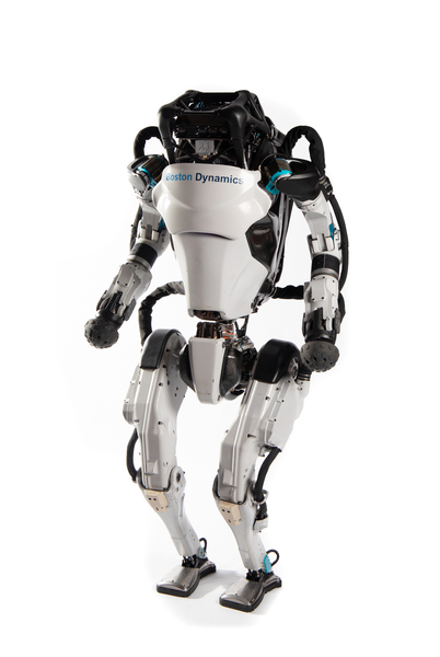 Photo of Atlas, a roughly human-shaped metal robot, standing on both feet.