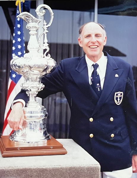 Photo of Jerome Milgram standing with his arm around the Americas Cup trophy