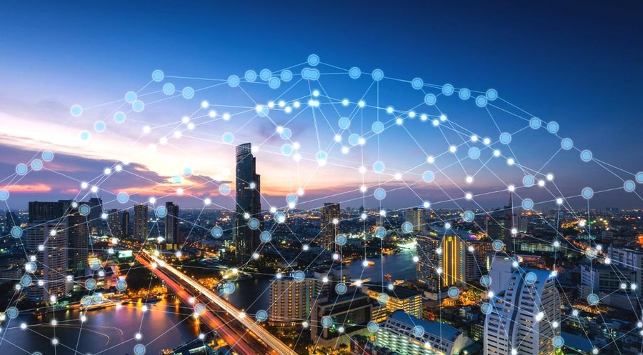 Photo of a sunset view of modern high rise buildings, with a river and bridge. An illustration of a network of connected nodes is laid over the photo.