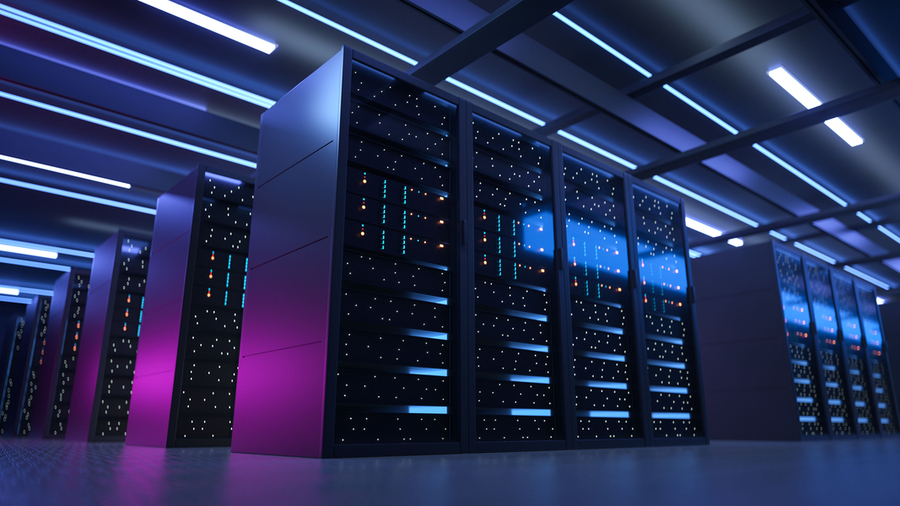 Photo of a bank of supercomputers, which are dimly lit in a dark room with purple and blue light