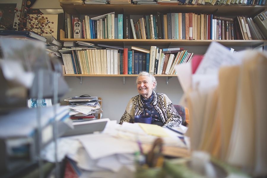 Photo of the late Mildred Dresselhaus smiling and framed by books and papers