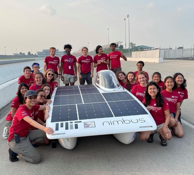 Cameron Kodesh and team pose around their car at the American Solar Challenge