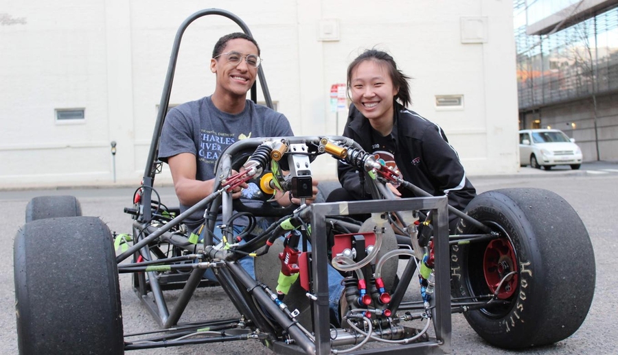 Photo of Cheyenne Hua (right) sitting beside a teammate in the motorsports frame