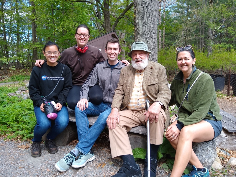 Photo of five people sitting on a bench in the woods: Pei Biorn-Hansen, Sav Hauge, Bjorn Hauge, Peter Grifith, and Melanie Griffith