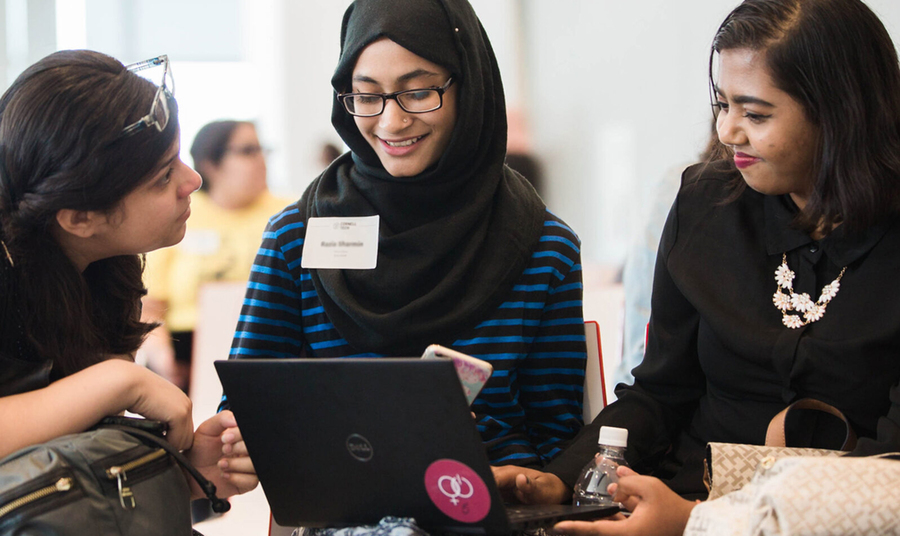 Photo of three women looking at a laptop