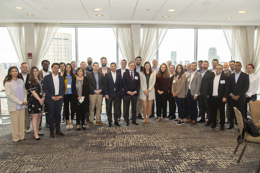A large group of people in business attire posing in a semicircle.