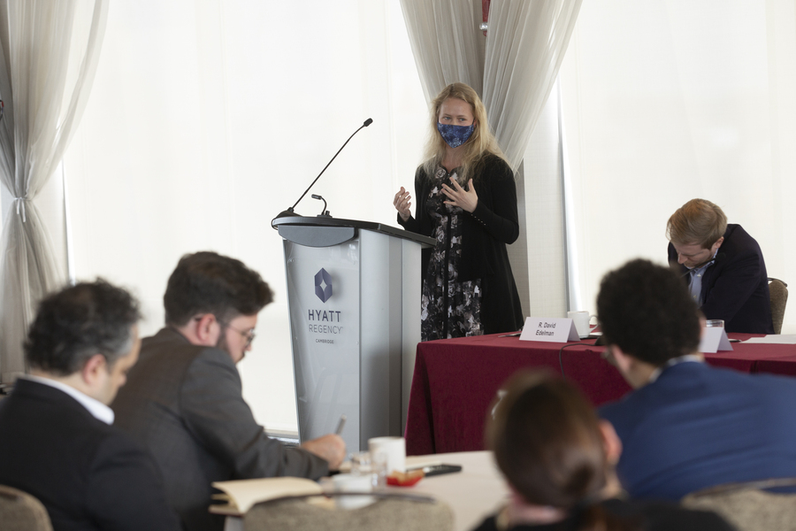 Photo of Mariya Grinberg standing at a podium, gesturing with her hands as she speaks