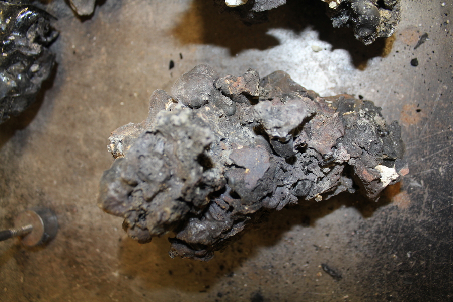 Photo of a piece of slag, which looks like brownish blackish rock composed of small chunks