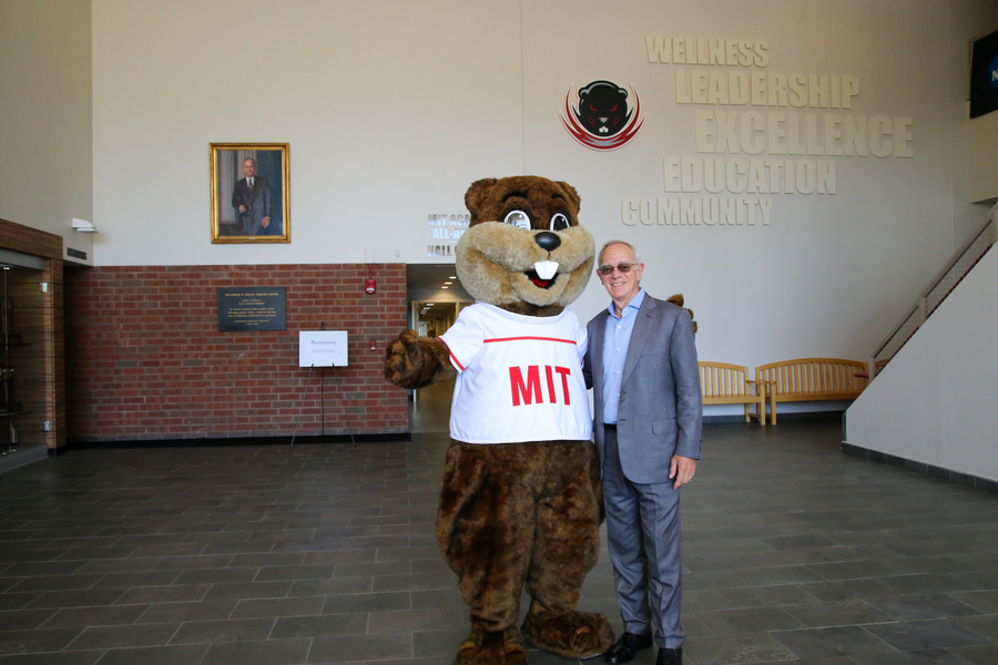 In the open main lobby of MIT’s Johnson Athletics Center, President Reif poses with Tim the Beaver.
