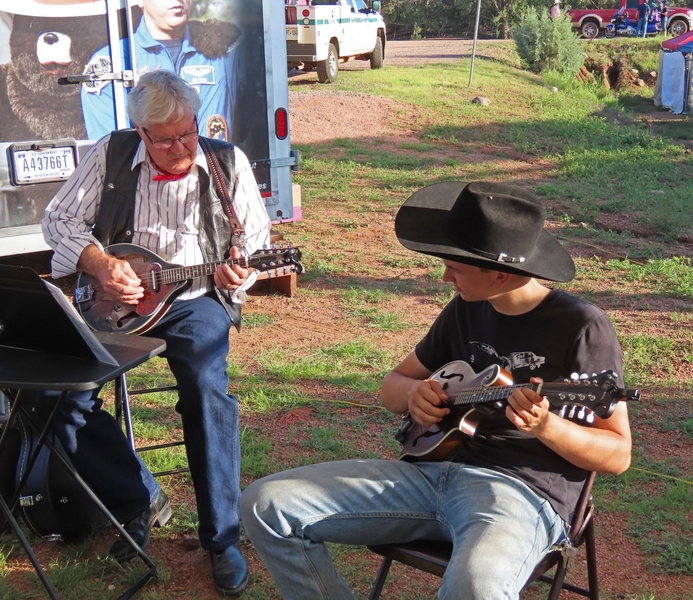 Photo of an older and a younger musician playing a mandolin duet
