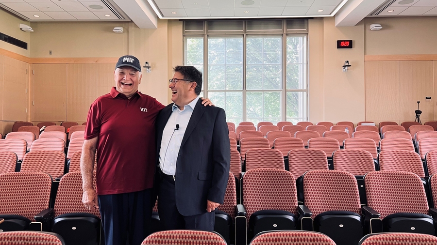 Jesus Sotomayor and David Nino stand together in an empty lecture hall, laughing together. Sotomayor has his hand on Nino’s shoulder.