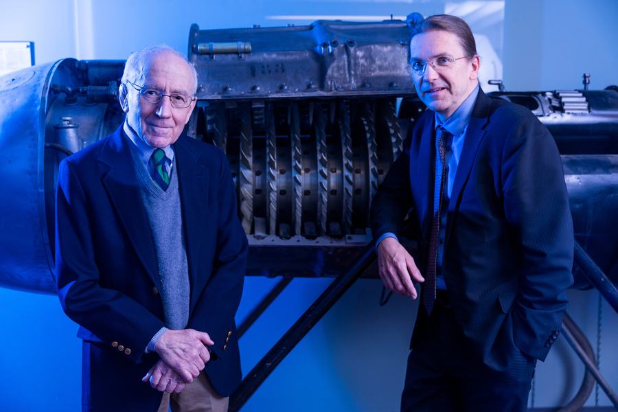 Zoltán Spakovszky and Edward Greitzer lean against large turbine engine machinery on display.