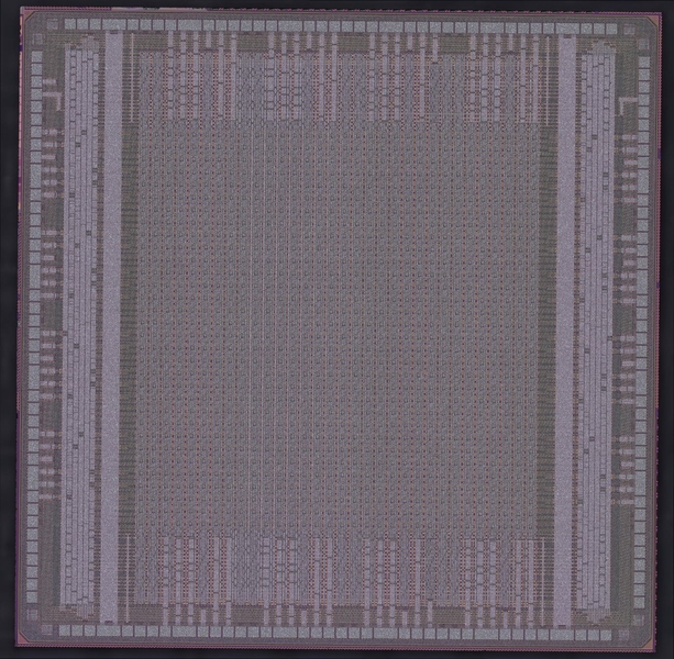 Closeup of an integrated circuit, which appears as a gray grid with thousands of slightly green and brown rectangles 