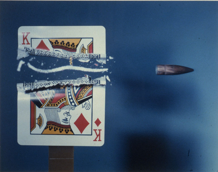 A bullet in flight cuts a playing card in half