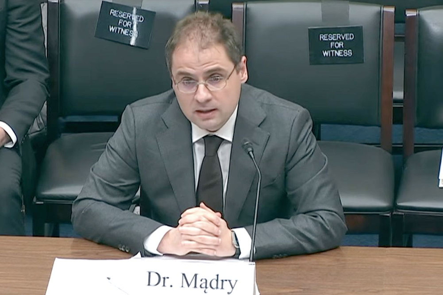 Aleksander Mądry testifies at a Congressional panel. A sign says "Dr. Madry"