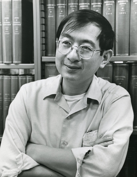 Black-and-white photo of Nelson Kiang in middle age, standing in front of a bookcase