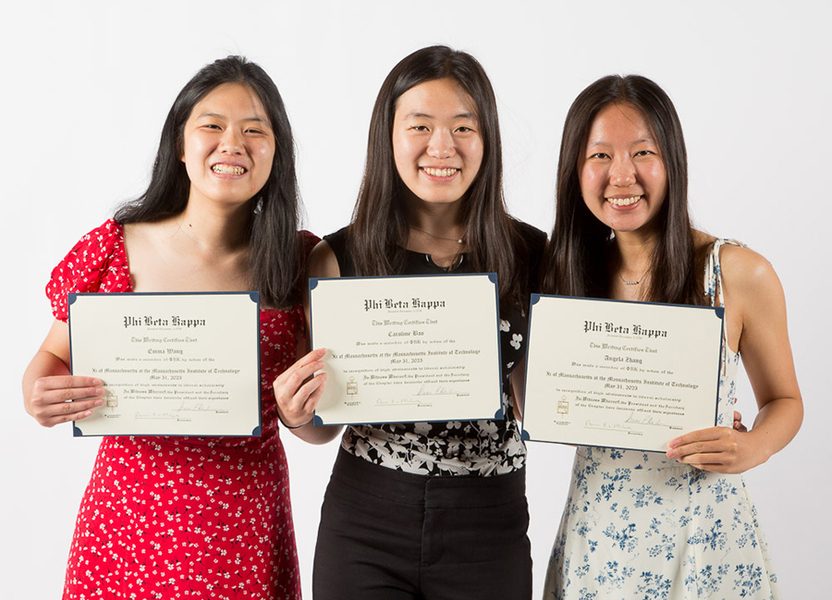 Emma Wang, Caroline Rao, and Angela Zhang hold up their Phi Beta Kappa certificates in front of a white background
