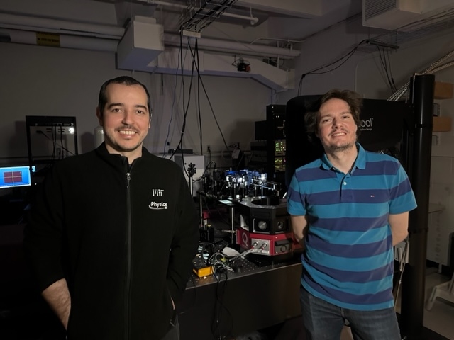 Luiz G. Pimenta Martins and Riccardo Comin stand inside a darkened lab room